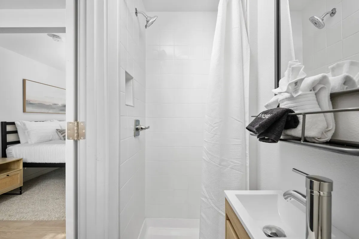 A bright, fresh bathroom featuring a modern shower area, soft towels, and a stylish sink. The space is inviting and clean, suggesting a comfortable spot to refresh after outdoor exploration.